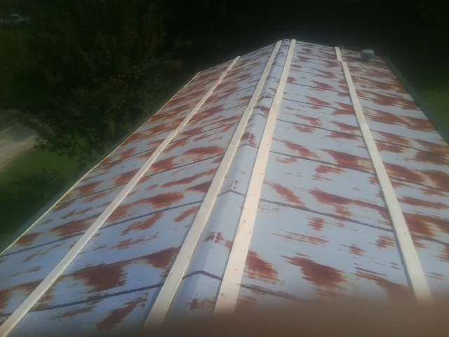 Rusted metal roof panels with new wood purlins before replacement — Storm Damage Roof Repair in Baldwinville by Roofing Brothers
